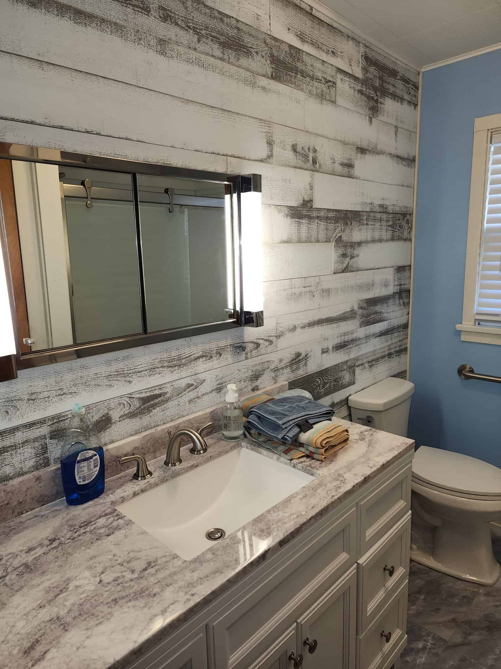 Bathroom vanity with tiled backsplash and finished wall surfaces