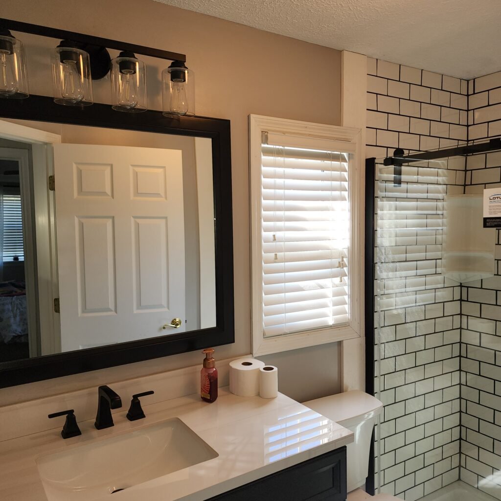 Completed bathroom remodel with glass shower enclosure, vanity, and tile walls