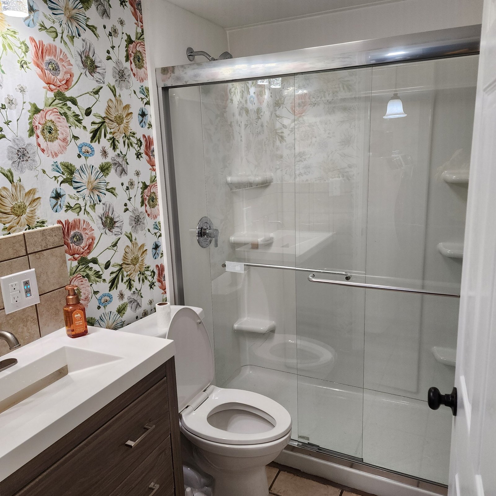 Clear sliding glass shower door installed beside a bathroom vanity
