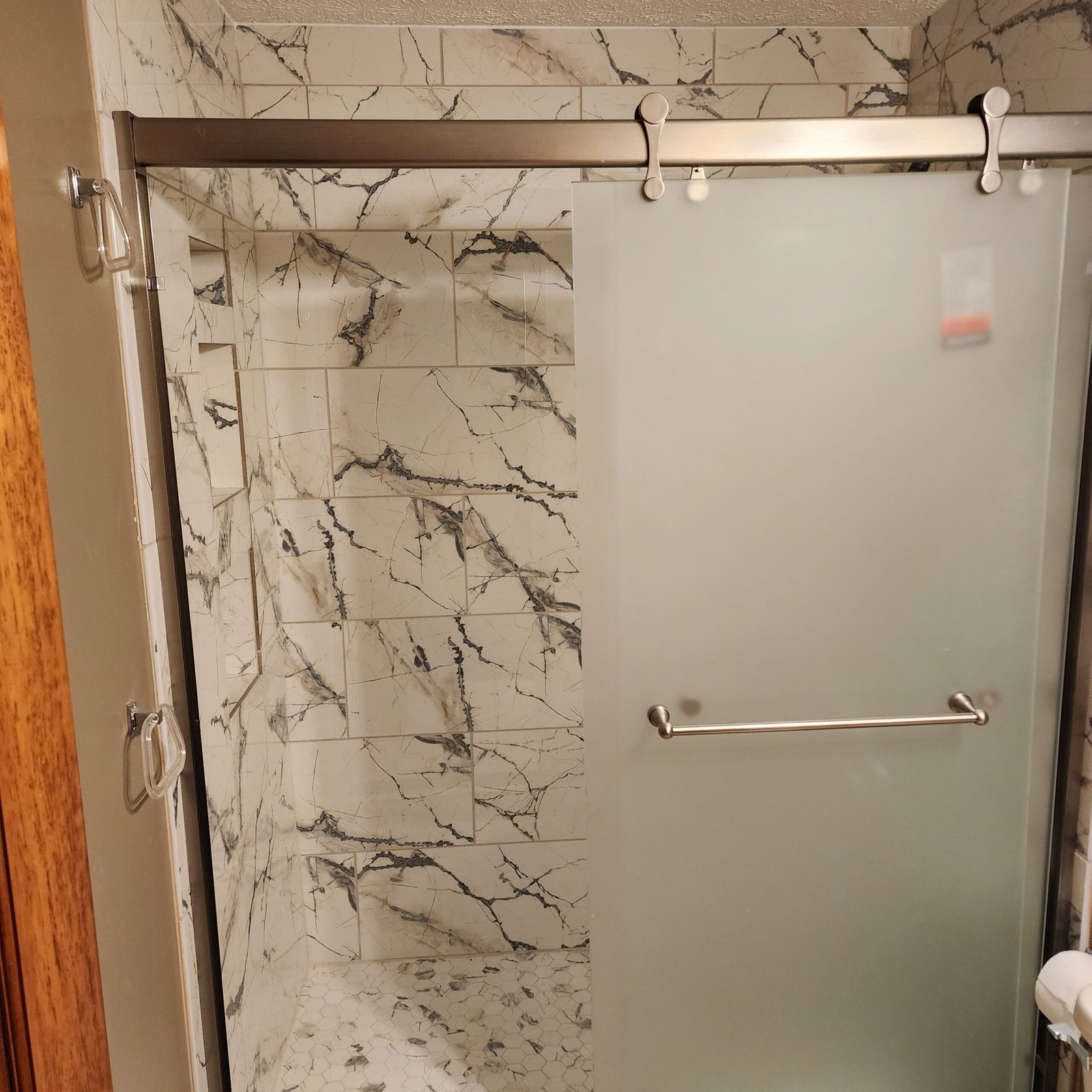 Frosted sliding glass shower door with a stainless steel handle