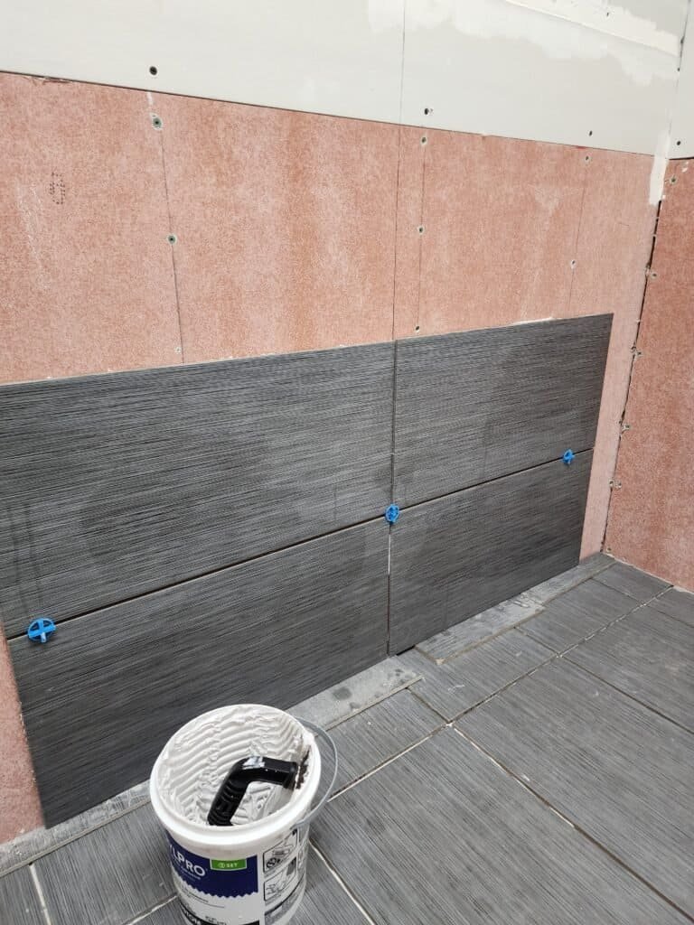 Bathroom wall tile being installed around a window opening