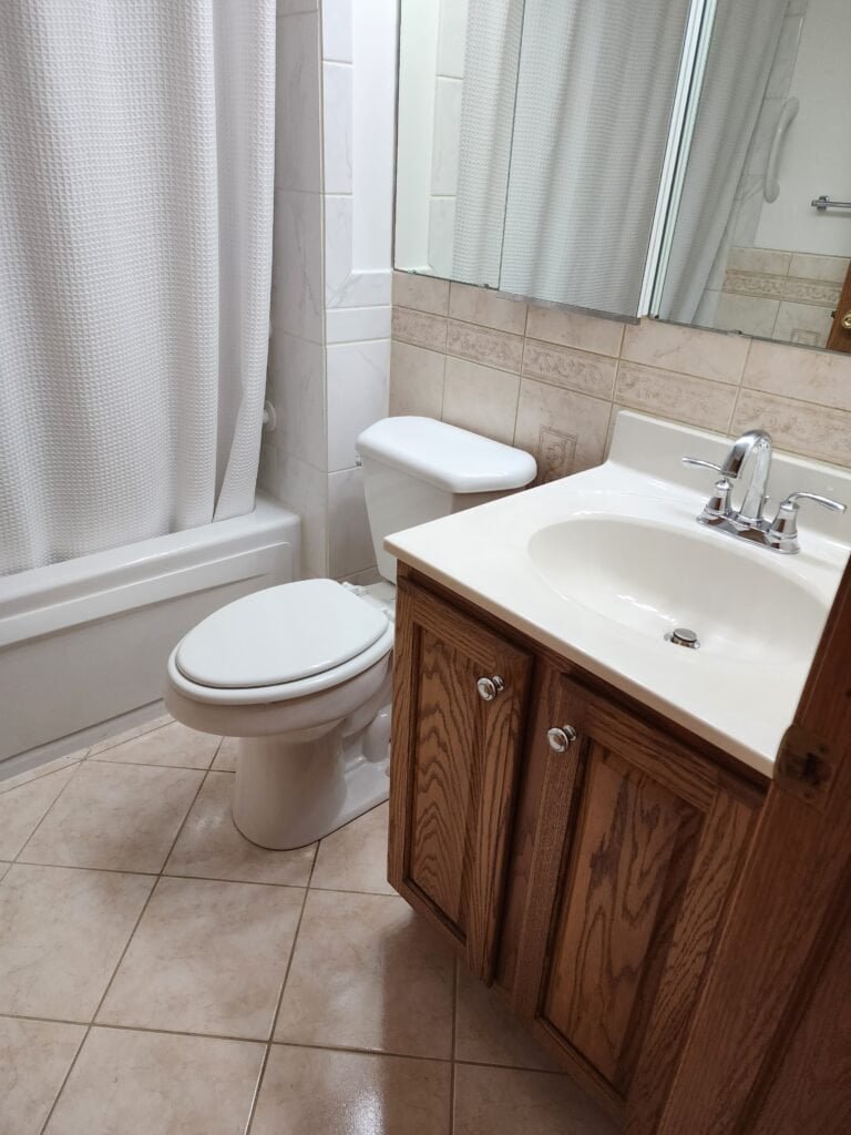 Existing bathroom with bathtub, toilet, vanity, wall tile, and floor tile